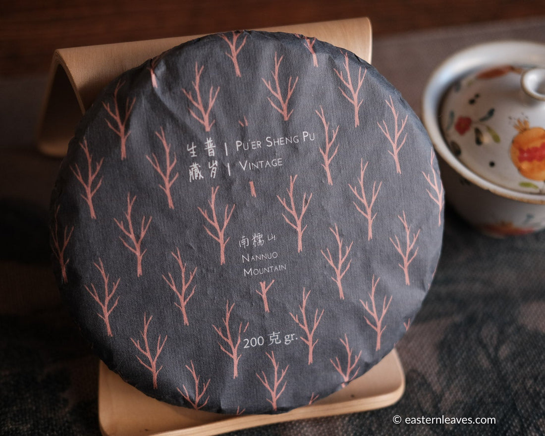 pu'er tea cake from nannuo mountain, Yunnan, 2008 harvest vintage aged, on bamboo tripod with hand painted gaiwan